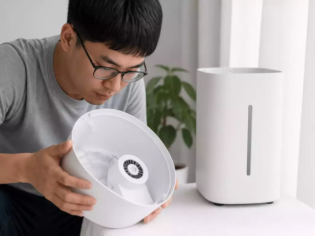 Person inspecting a humidifier for moisture after cleaning