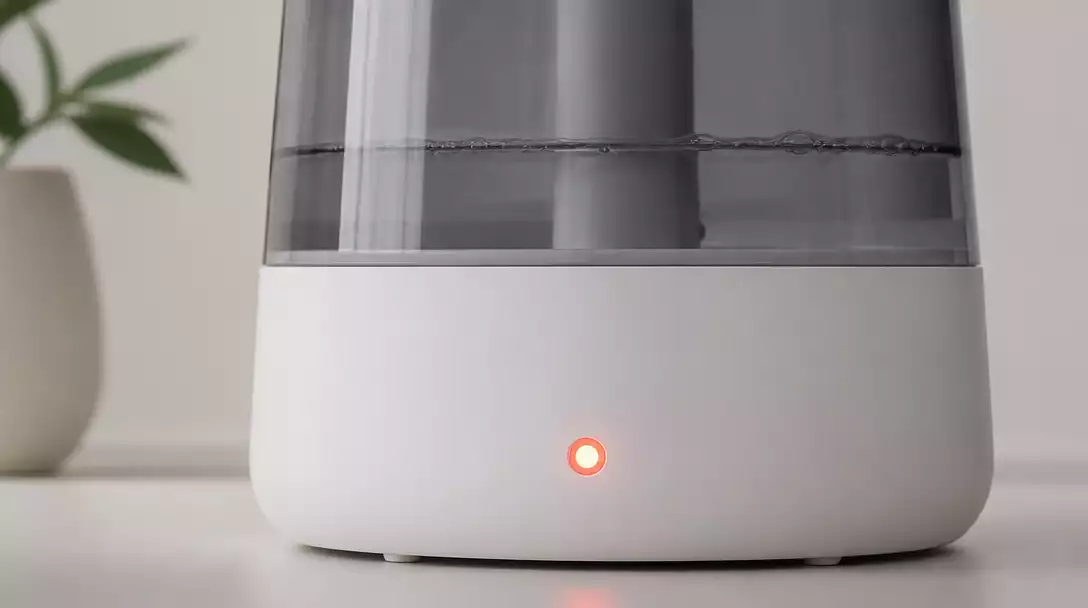 Close-up of a Geniani humidifier with a glowing red indicator light, clean, modern design