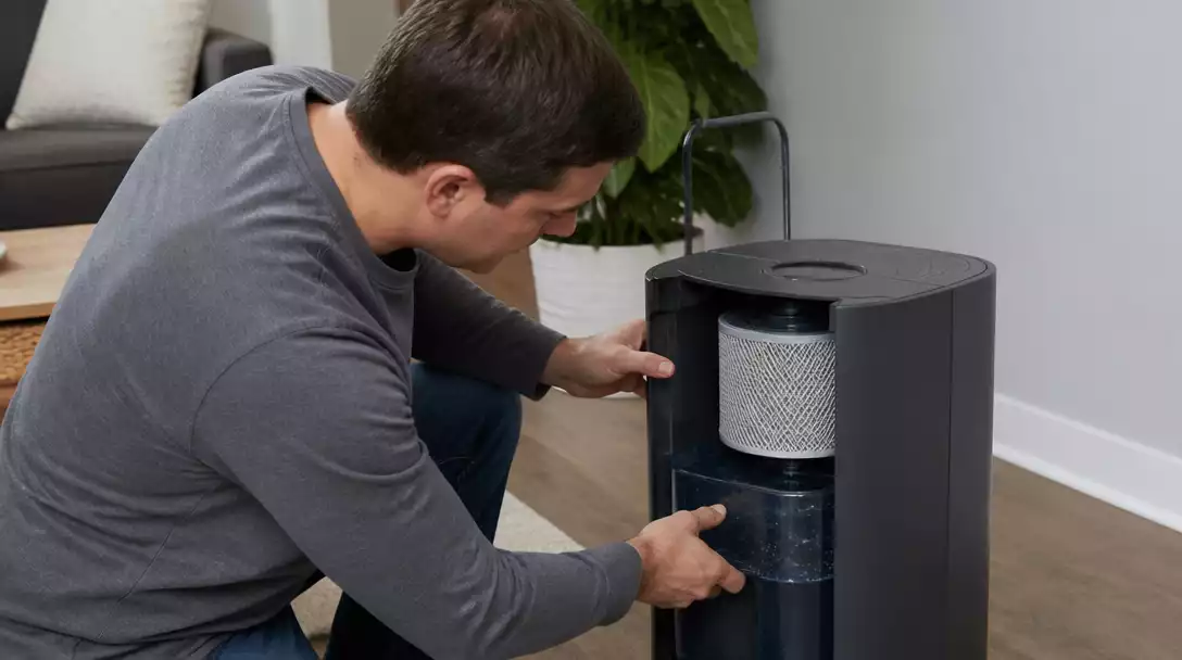 Person inspecting a Honeywell humidifier for issues