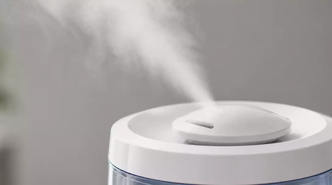 Close-up of a Honovos humidifier emitting a fine, visible mist, with a focus on the mist output nozzle and a clean background, no text, no words, no typography, no labels, clean image