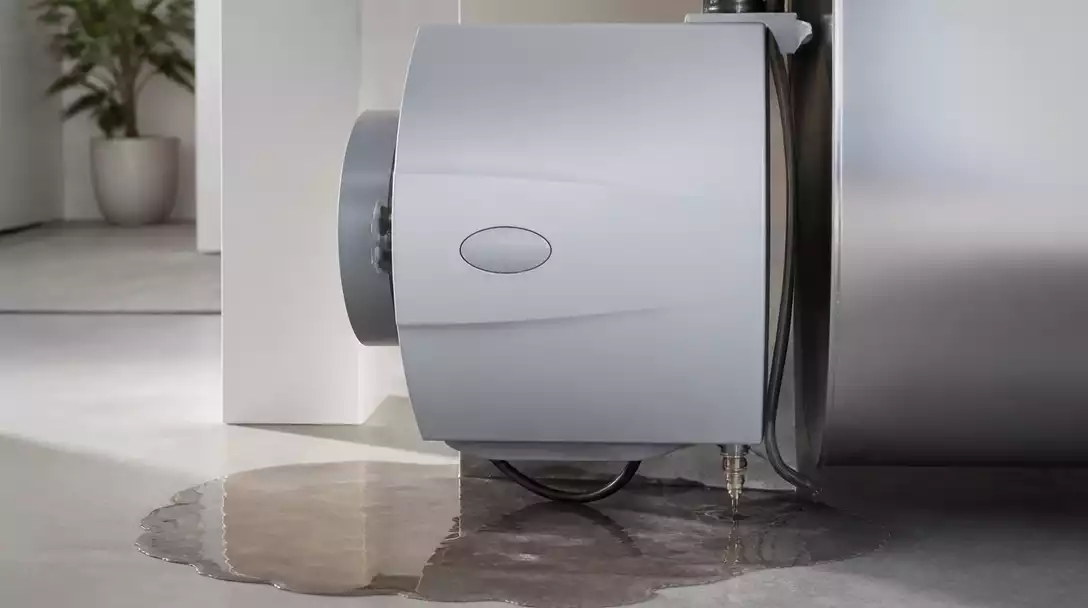 AprilAire humidifier with water pooling around it, highlighting a leak issue