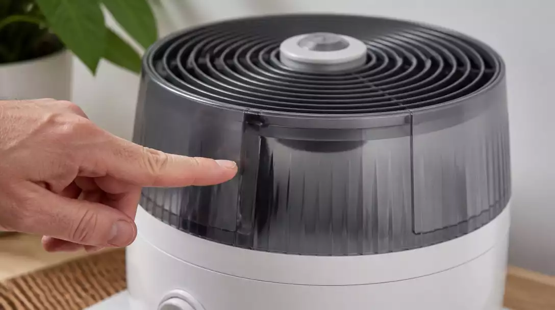 Close-up of a Honeywell humidifier fan with a hand pointing to a potential issue, illustrating troubleshooting